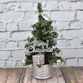 Mini silberner Weihnachtsbaum im gewebten Topf mit Festschmuck auf Holztisch - 20cm / Silber