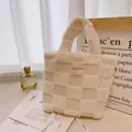 Macro view of cream waffle texture lamb wool handbag with square woven brand label - Off-white