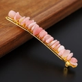 Macro shot of pink natural crystal stones hand-wrapped on a golden metal hair pin - Pink Opal + Gold Clip