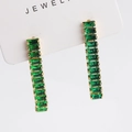 Boucles d'oreilles pendantes dorées avec zircons verts rectangulaires sur carte blanche - Boucles d'Oreilles en Pierre Verte