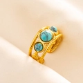 Detail of twisted gold ring band with three turquoise stones in a vintage boho style - Gold-Turquoise Zirconia