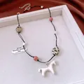 Macro detail of horse pendant necklace with colorful stone beads on white tray - Necklace - Silver - Pink
