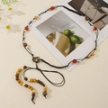 Close-up of Bohemian woven belt featuring colorful wooden beads and metallic buckle detail - Orange