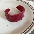 Detail view of burgundy acrylic cuff bracelet with marble texture and wavy pleated design - Rose Red