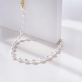Detailed view of baroque pearl necklace with golden lobster clasp on a stone decor - Alternating Large and Small Pearls