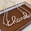 Collier en or élégant avec perles blanches formant des lettres d'art dans un écrin brun - Or Blanc (97# Chaîne de corps)