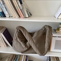 Dettaglio di una borsa tote kaki trapuntata con una texture morbida su scaffale bianco - Cachi