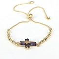 Detailed macro view of the gold bolo bracelet with purple zircon stone cross pendant - Purple