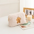 Détail d'une trousse à maquillage rose en peluche avec broderie caniche et perle au zip - Caniche