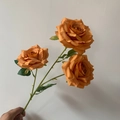 Artificial bouquet with three blooming burnt orange roses and green leaves - Orange