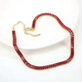 Macro detail of rectangle cut red rubies on a gold necklace with adjustable extension chain - Rose Red