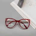 Close-up of red transparent cat-eye frames with golden metal spring-leg temples - Transparent Tea
