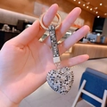 Close-up of heart-shaped keychain with black and white rhinestones and golden ring - Black