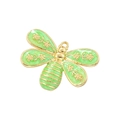 Macro view of a gold dragonfly pendant featuring sparkling green enamel wings - Green