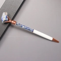 Detail of rose gold metal ballpoint pen featuring blue crystal stones in a clear tube - Lapis Lazuli