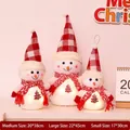 Three glowing plush snowman dolls with red plaid hats and warm LED lights in varied sizes - Glowing Snowman Family of Three