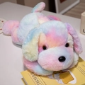 Liegender Regenbogen-Plüschhund mit buntem weichem Fell auf einem Buch - 50cm / Bunt