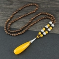 Ethnic style long wood bead necklace with a large yellow amber teardrop pendant - Resin Yellow Teardrop
