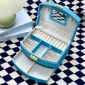 Top view of blue leather jewelry box with mirrors and drawers on checkerboard desk - Light Blue