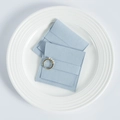 Detail of light blue microfiber suede jewelry pouch with gold pearl ring on ceramic plate - Blue