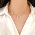 Double-layered gold pearl necklace with zircon accents on elegant female model - Layered Gold