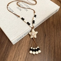 Close-up of ceramic starfish pendant with woven rope and beads on a vintage book - Starfish (White) / White