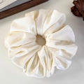 Detailed close-up of cream-colored oversized satin scrunchie with soft silk texture - Cream