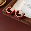 Detailansicht der vergoldeten roten Rosenohrringe mit funkelnden Strass-Blumenakzenten - Rote Rose Stil