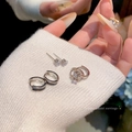 Detail of silver bow earrings set with rhinestones held on white knit sweater - E5829 Silver
