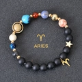 Detail of Aries zodiac charm with colorful planetary beads on a matte black stone bracelet - Aries