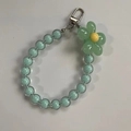 Detailed view of mint green beaded phone strap with a blooming flower charm and silver clasp - Green Beads Green Flower