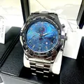 Macro shot of men's quartz watch with blue dial, steel band, and date window display - Silver Band Blue Dial