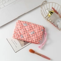 Close-up of quilted red gingham cosmetic bag with bow embroidery and corded zipper pull - Red Grid with Bow