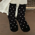 Women's black crew socks featuring white heart patterns and ruffled lettuce trim edges - One Size / Black