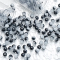 Detailed view of 10mm black and white gradient glass beads spilling from clear tubes - 10mm / Black and White