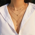 Golden multi-layer necklace with heart beads and starfish pendant on female model - Gold Heart