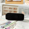 Black corduroy pencil case with smiling faces design on a student desk setting - Black Heart-Eye Pencil Case