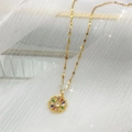 Luxe goudvergulde bloem ketting met kleurrijke zirkonia op witte tule stof - Bloemblad