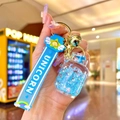 Close-up of blue unicorn liquid sand bottle keychain with silver star sequins and bell - Blue Luminous Bubble Bead Gas Tank