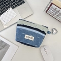 Detail van patchwork denim etui met strikborduursel en dubbele ritsen op bureau - Donkerblauw Strik