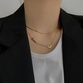 Dubbellaagse gouden titanium ketting met hart- en Love-hanger gedragen door een model - Dubbellaagse Hart Titanium Staal Ketting