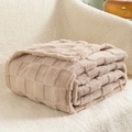 Thick checkered flannel blanket in beige-coffee color folded on a cream sofa - Khaki