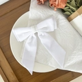 Detail of white velvet bow hair clip with long ribbons on elegant lifestyle background - White
