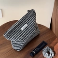 Dettaglio della trousse in tweed bianco e nero con texture intrecciata e zip superiore - Nero e Bianco