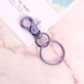 Matte haze blue lobster clasp keychain with rotating hook and open ring on marble background - Dark Gray