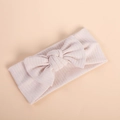 Detail of baby headband featuring soft ribbed knit fabric and a large bow in pale pink - Off White