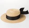 Detailed close-up of a natural straw boater hat featuring an elegant wide black ribbon bow. - One Size / Black Ribbon Style