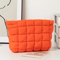 Quilted puffer clutch bag in vibrant orange featuring square stitching and metal hardware - Orange