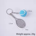 Mini silver tennis racket keychain with blue felt ball on a light purple background - 2.5cm Large Blue Tennis Ball + Silver Racket