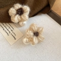 Detalle de pendientes de flor tejida beige con una perla blanca y centro marrón - Marrón